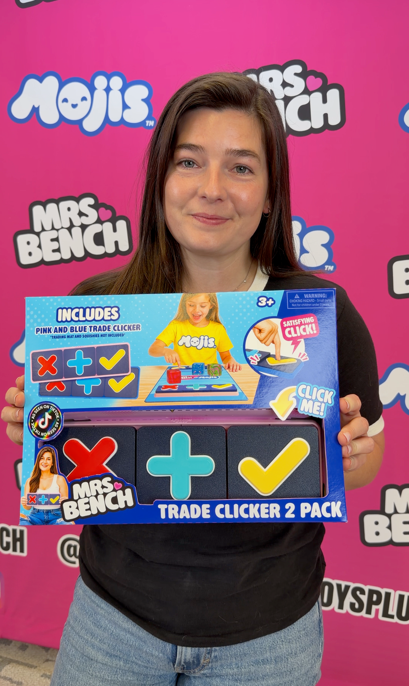 Mrs. Bench holding the Trade Clicker 2-Pack package with pink and blue clickers.